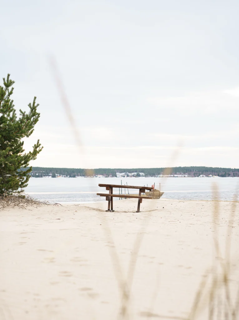 Bild på en bänk som står på en strand.